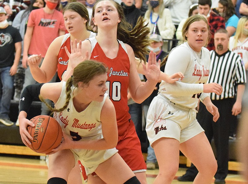 RICK PECK/SPECIAL TO MCDONALD COUNTY PRESS McDonald County's Sydney Killion looks for maneuvering room during Carl Junction's 60-24 win on Jan. 4 at MCHS.