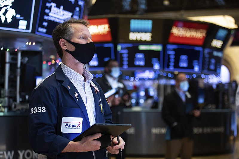 In this photo provided by the New York Stock Exchange, trader Robert Charmak works on the floor, Tuesday, Jan. 5, 2021. U.S. stocks are wobbling between small gains and losses on Tuesday, a day after dropping to their worst loss in months amid the worsening pandemic and potentially market-moving Senate elections. (Colin Ziemer/New York Stock Exchange via AP)