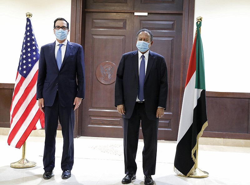Sudanese Prime Minister Abdullah Hamdok, right, welcomes US Treasury Secretary Steven Mnuchin to the Cabinet Building, in Khartoum, Sudan, Wednesday, Jan. 6, 2021. The U.S. and Sudan have agreed to settle the African country's debt to the World Bank. The move comes after Mnuchin arrived in Sudan, the first visit by a senior American official since President Donald trump removed Sudan from the list of state sponsors of terrorism. (AP Photo)