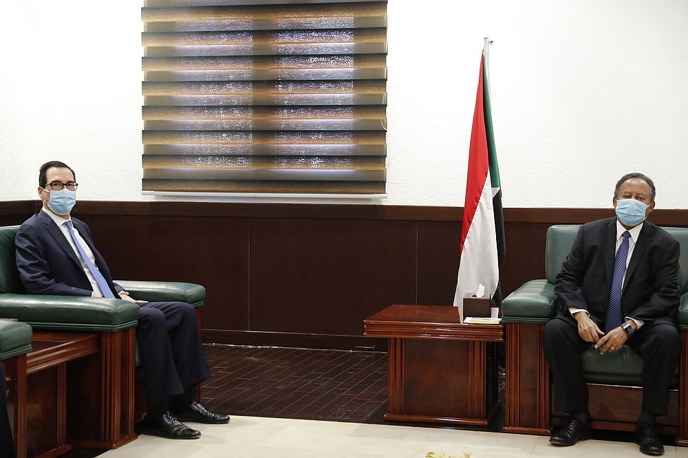 Sudanese Prime Minister Abdullah Hamdok, right, meets with US Treasury Secretary Steven Mnuchin in the Cabinet Building, in Khartoum, Sudan, Wednesday, Jan. 6, 2021. The U.S. and Sudan have agreed to settle the African country's debt to the World Bank. The move comes after Mnuchin arrived in Sudan, the first visit by a senior American official since President Donald trump removed Sudan from the list of state sponsors of terrorism. (AP Photo)