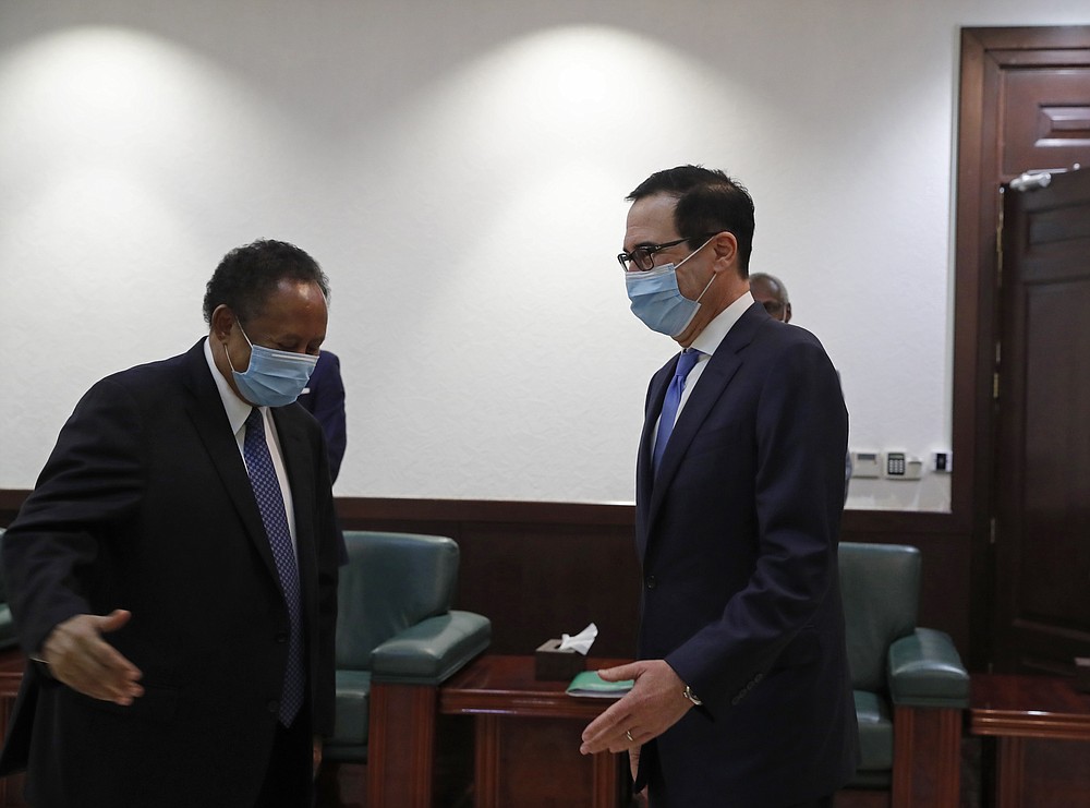 Sudanese Prime Minister Abdullah Hamdok, right, welcomes US Treasury Secretary Steven Mnuchin to the Cabinet Building, in Khartoum, Sudan, Wednesday, Jan. 6, 2021. The U.S. and Sudan have agreed to settle the African country's debt to the World Bank. The move comes after Mnuchin arrived in Sudan, the first visit by a senior American official since President Donald trump removed Sudan from the list of state sponsors of terrorism. (AP Photo)