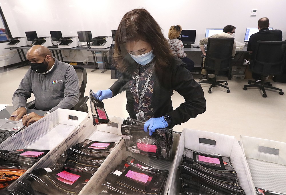 Election workers tabulate ballots at the Beauty P. Baldwin Voter Registrations and Elections Building, Tuesday, Jan. 5, 2021, in Lawrenceville, Ga. (Curtis Compton/Atlanta Journal-Constitution via AP)