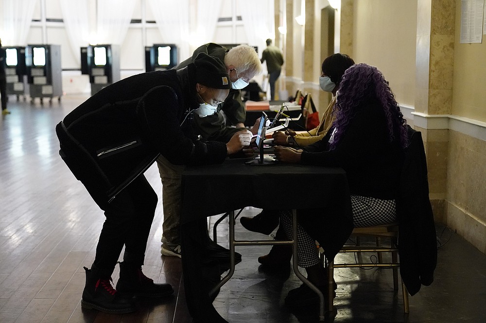 Voters register before casting their vote during Georgia's Senate runoff elections on Tuesday, Jan. 5, 2021, in Atlanta. (AP Photo/Brynn Anderson)