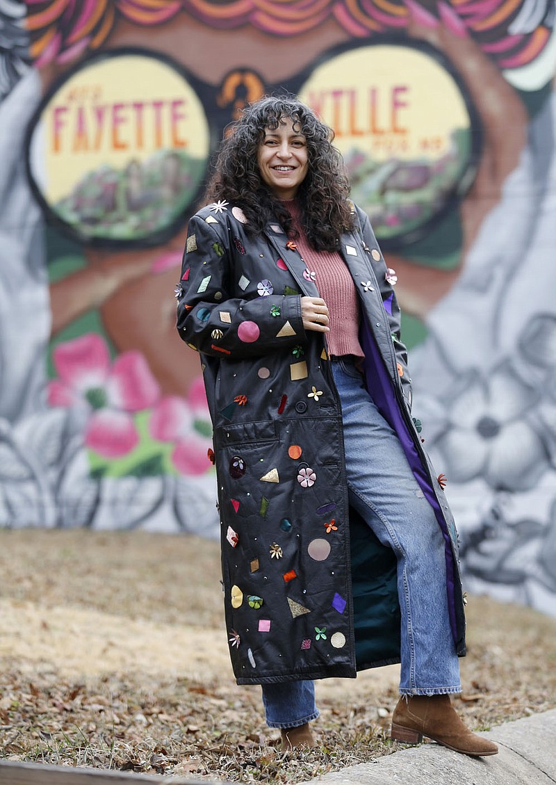 Designer Brandy Lee displays an up-cycled leather coat featuring leather cutouts, rhinestone and leather flowers Tuesday, Dec. 29, 2020, outside of her studio in Fayetteville. The Arkansas Arts and Fashion Forum said the pandemic has caused the need for changing how the industry operates, to include creating more of a reliance on American-made products and processes that will prevent lags in the industry in the future. Lee is creating a collection of jackets that she will be releasing after the first of the year. Check out nwadg.com/photos for a photo gallery.
(NWA Democrat-Gazette/David Gottschalk)