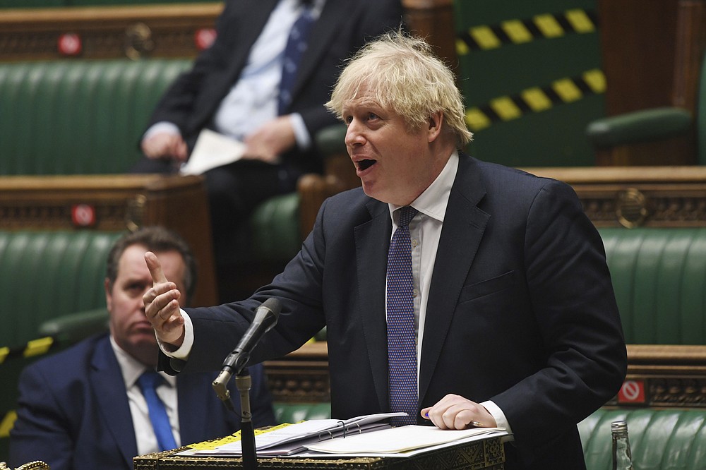 In this handout photo provided by UK Parliament, Britain's Prime Minister Boris Johnson makes a statement to the Commons updating MPs in the House of Commons, London, Wednesday, Jan. 6, 2021 on the latest situation with the Coronavirus pandemic. British lawmakers were recalled from their Christmas recess to discuss new restrictions that took effect at midnight as part of England's third national lockdown. (Jessica Taylor/UK Parliament via AP)