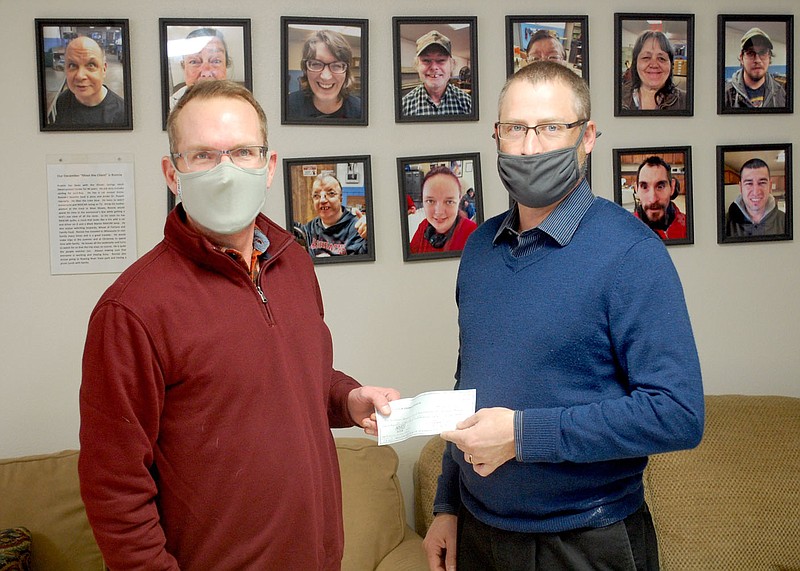 Janelle Jessen/Herald-Leader
Bernie Krumpelman (right), committee chair for the Knights of Columbus Campaign for Persons with Intellectual Disabilities, presents a $425 donation to Kolin Blakely, executive director of the Adult Development Center, on Wednesday. Siloam Springs Knights of Columbus, which is a part of St. Mary Catholic Church, raises money each year through the fundraiser, also known as the Tootsie Roll Campaign.