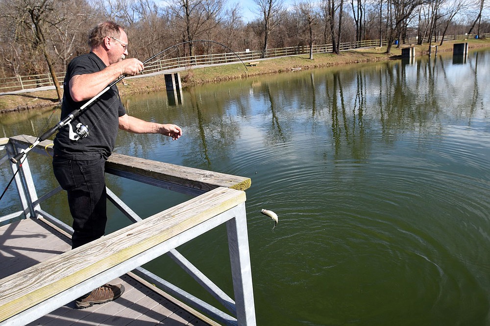 Joe Needham of Fayetteville lands a trout Dec. 26 2020 he caught with Power Bait at Lake Springdale.
(NWA Democrat-Gazette/Flip Putthoff)