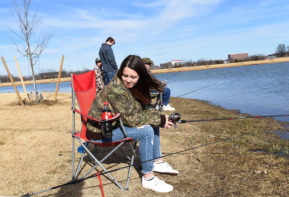 Alexis Vidal checks her fishing pole on Dec. 26 2020 at Lake Bentonville.
(NWA Democrat-Gazette/Flip Putthoff)