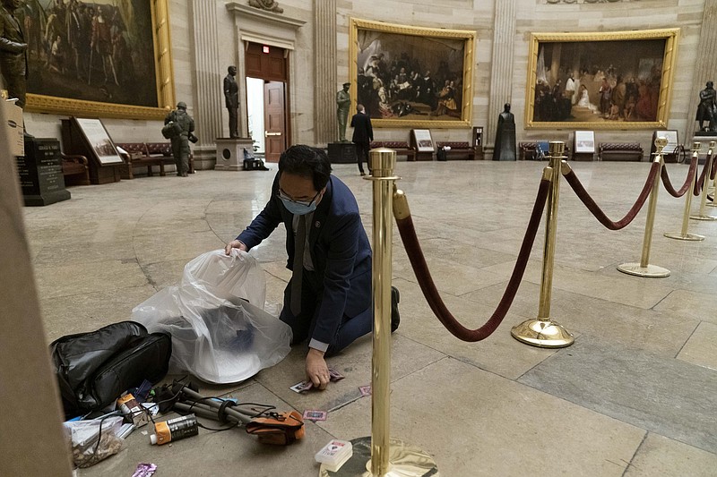 AP Photo/Andrew Harnik
Rep. Andy Kim, D-N.J., cleans up debris and personal belongings strewn across the floor of the Rotunda in the early morning hours of Thursday after protesters stormed the Capitol in Washington, on Wednesday.