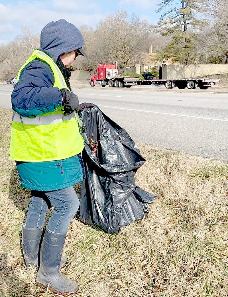 Sally Carroll/Special to The Weekly Vista
Marci Downing picks up trash along Highway 71 as part of the Pick The Town Green effort. Downing said the effort is a personal issue for her. She dislikes seeing trash around the village, she said.