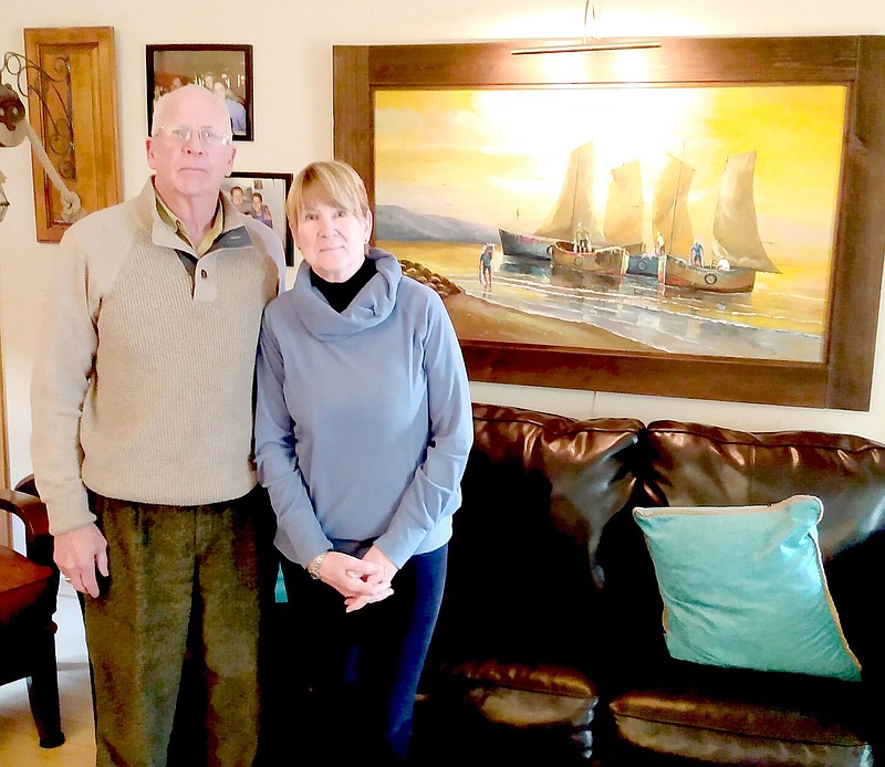 Keith Bryant/The Weekly Vista
Bella Vista residents Phillip and Catherine Schoeppe stand in front of a painting they commissioned of fishing boats on the Ecuadorian coast.