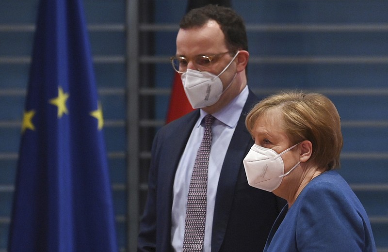 German Chancellor Angela Merkel and Federal Health Minister Jens Spahn  arrive at the weekly cabinet meeting wearing face masks Wednesday in Berlin, Germany. The coronavirus pandemic is colliding with politics as Germany embarks on its vaccination drive and one of the most unpredictable election years in its post-World War II history. - John Macdougall/Pool via AP