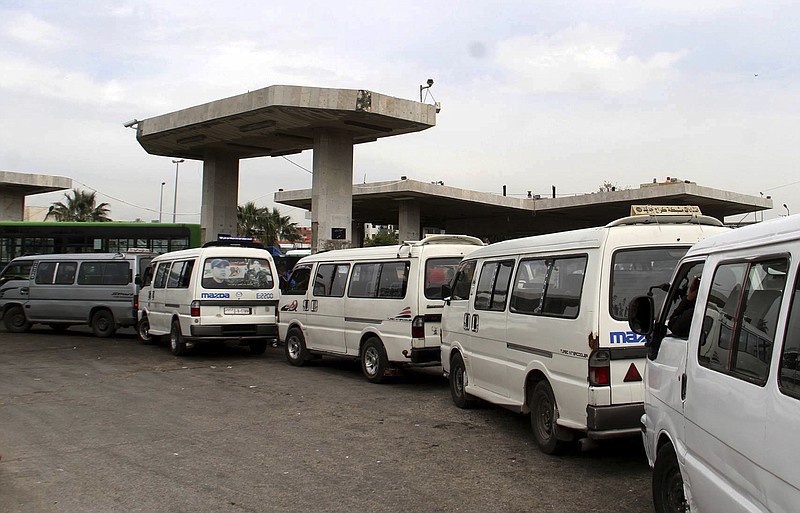FILE - In this file photo released on April 7, 2019, by the Syrian official news agency SANA, shows vans queuing to fill their tanks with fuel, at a gas station in Daraa, south Syria.  On Sunday, Jan. 10, 2021, Syria’s petroleum ministry blamed U.S. sanctions for forcing it to cut by up to 24% its distribution of fuel and diesel because of delays in arrival of needed supplies. (SANA via AP, File)
