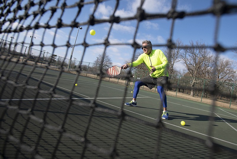 Ben Catterlin of Greenland hits a pickleball Monday while practicing at Walker Park in Fayetteville. Catterlin uses a device called a Lobster to launch balls for him to hit while practicing alone, usually hitting between 500-900 ball in a session.  He has played pickleball for nearly two years and plays four times a week when the weather is nice. Visit nwaonline.com/210112Daily/ and nwadg.com/photos. (NWA Democrat-Gazette/J.T. Wampler