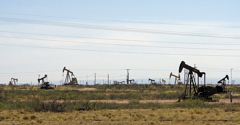 FILE - In this April 9, 2014, file photo, oil rigs stand in the Loco Hills field on U.S. Highway 82 in Eddy County near Artesia, N.M., one of the most active regions of the Permian Basin. In the closing months of the Trump administration energy companies stockpiled enough drilling permits for western public lands to keep pumping oil for years. That stands to undercut President-elect Joe Biden's plans to block new drilling on public lands to address climate change. (AP Photo/Jeri Clausing, File)