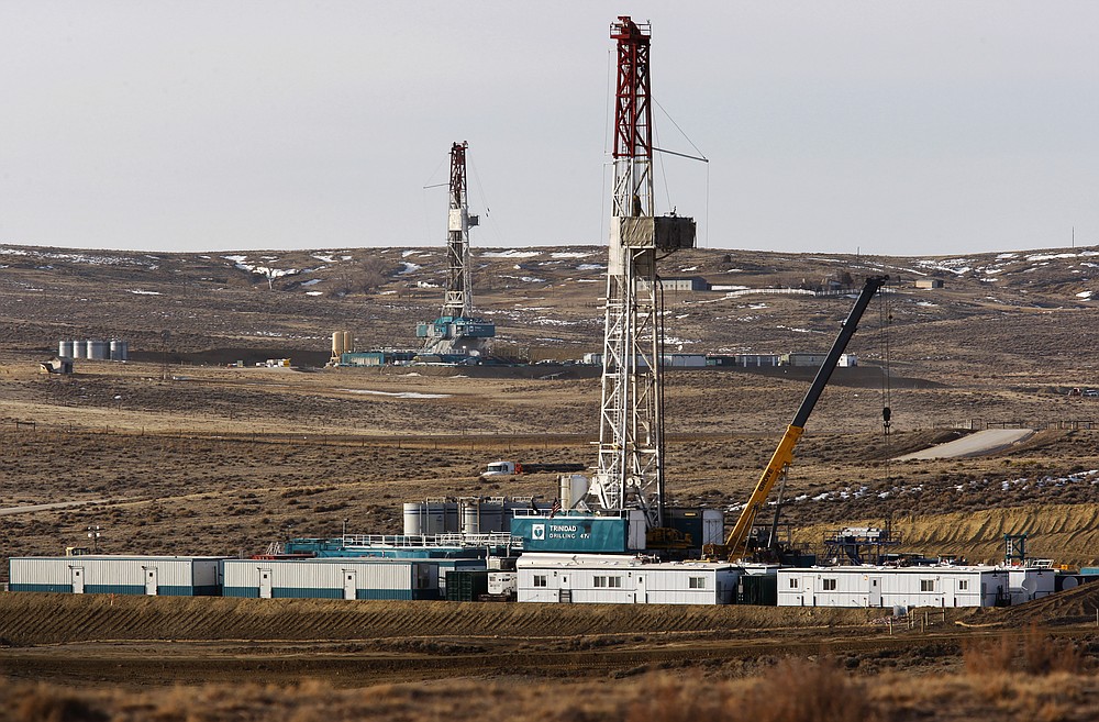 FILE - In this March 5, 2013, file photo, Trinidad Drilling rigs stand near Highway 59 outside Douglas, Wyo. In the closing months of the Trump administration, energy companies stockpiled enough drilling permits for western public lands to keep pumping oil for years. That stands to undercut President-elect Joe Biden's plans to block new drilling on public lands to address climate change. (Leah Millis/The Casper Star-Tribune via AP, File)