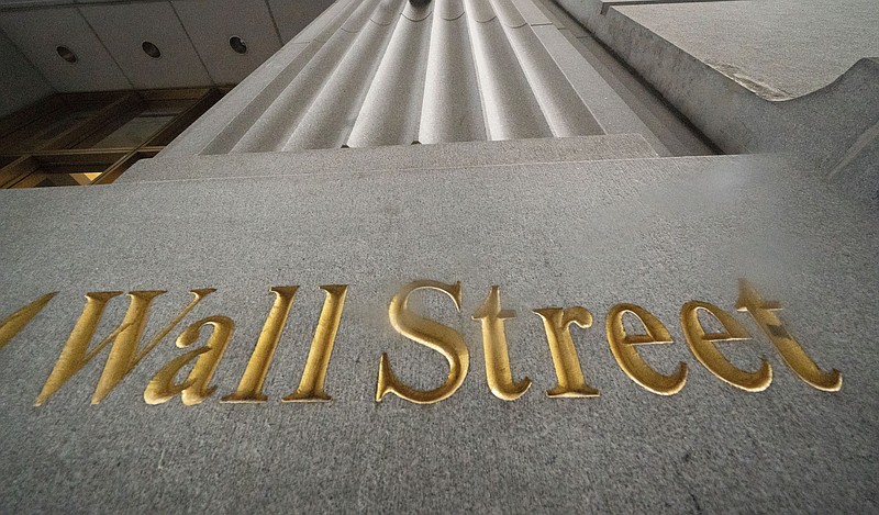 FILE - In this Nov. 5, 2020 file photo, a sign for Wall Street is carved in the side of a building. Stocks are slipping Monday, Jan. 11, 2021, as trading cools in markets around the world following their strong record-setting runs. (AP Photo/Mark Lennihan, File)