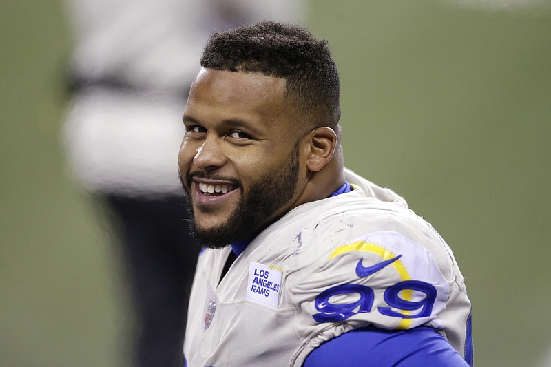 Los Angeles Rams defensive end Aaron Donald smiles as he stands on the sideline late in the second half of an NFL wild-card playoff football game against the Seattle Seahawks, Saturday, Jan. 9, 2021, in Seattle. (AP Photo/Scott Eklund)
