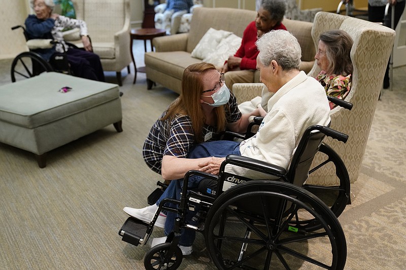 Naomi Adams checks on residents after they received the Pfizer COVID-19 vaccine at Monarch Villa memory care facility Monday, Jan. 11, 2021, in Stockbridge, Ga. The center director Pat Mobley says all 26 residents of the home were scheduled to be vaccinated. (AP Photo/John Bazemore)