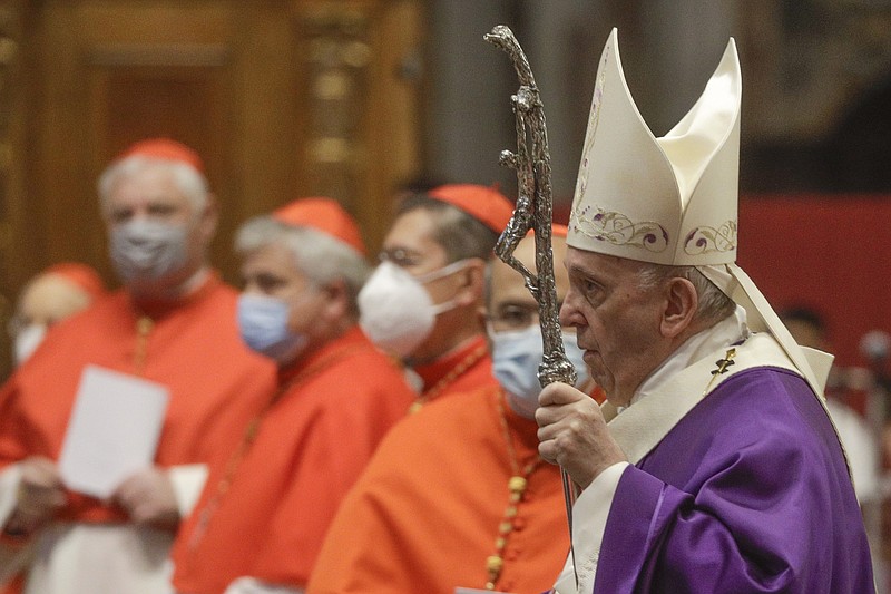 FILE - In this file photo dated  Sunday, Nov. 29, 2020, Pope Francis holds his pastoral staff as he arrives to celebrate Mass, at St. Peter's Basilica.  Pope Francis has changed church law to explicitly allow women to do more things during Mass, Monday Jan. 11, 2021, while reaffirming they cannot be priests. (AP Photo/Gregorio Borgia, FILE)