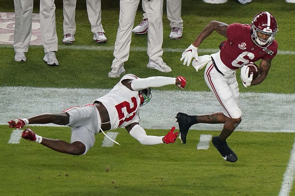 Alabama wide receiver DeVonta Smith runs past Ohio State cornerback Marcus Williamson during the first half of an NCAA College Football Playoff national championship game, Monday, Jan. 11, 2021, in Miami Gardens, Fla. (AP Photo/Wilfredo Lee)
