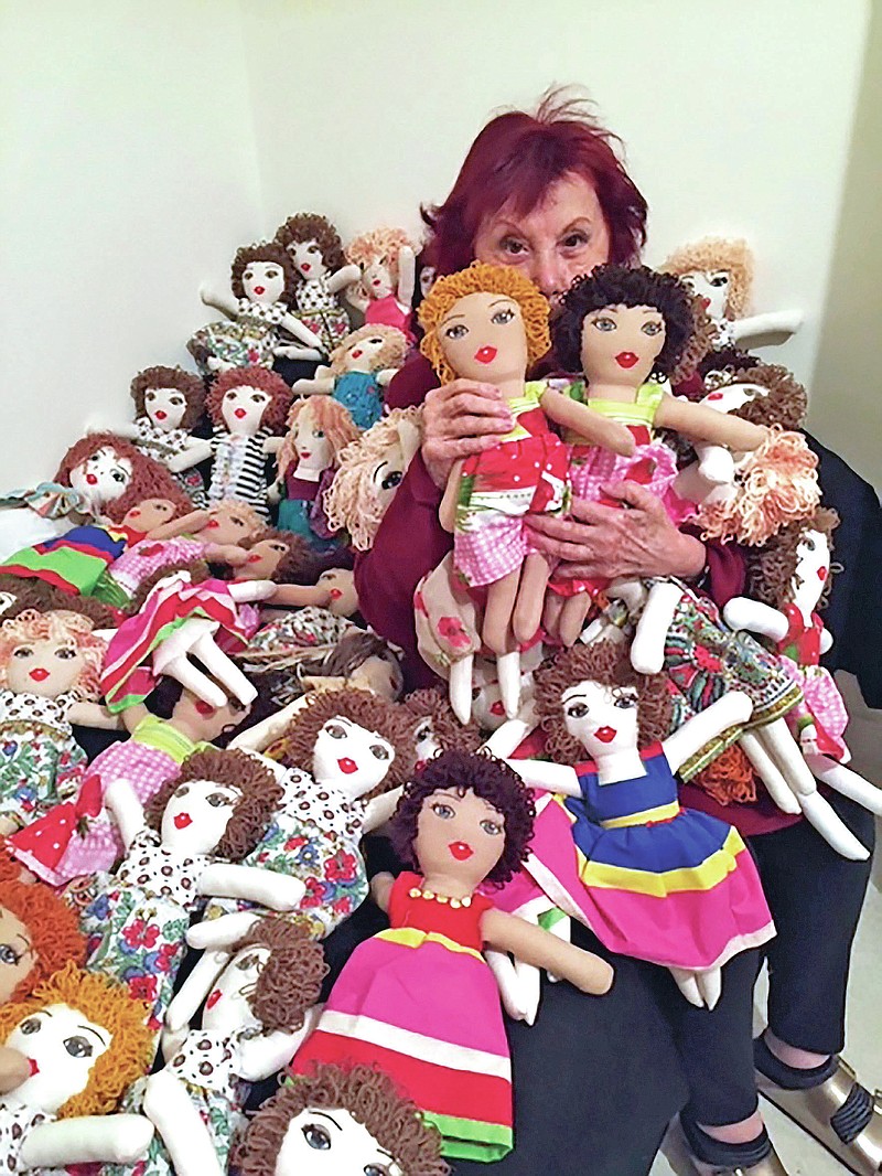 In this photo provided by Lebanese painter Yolande Labaki, Labaki, 93, holds dolls at her house in Beirut, Lebanon, Monday, Nov. 16, 2020, that she made to be distributed to children who might have lost their toys amid the destruction or who had otherwise had their lives touched by the Beirut seaport blast in August 2020. After the massive explosion devastated Beirut, Labaki made 100 dolls for children affected by the destruction. (Yolande Labaki via AP) story.lead_photo.caption