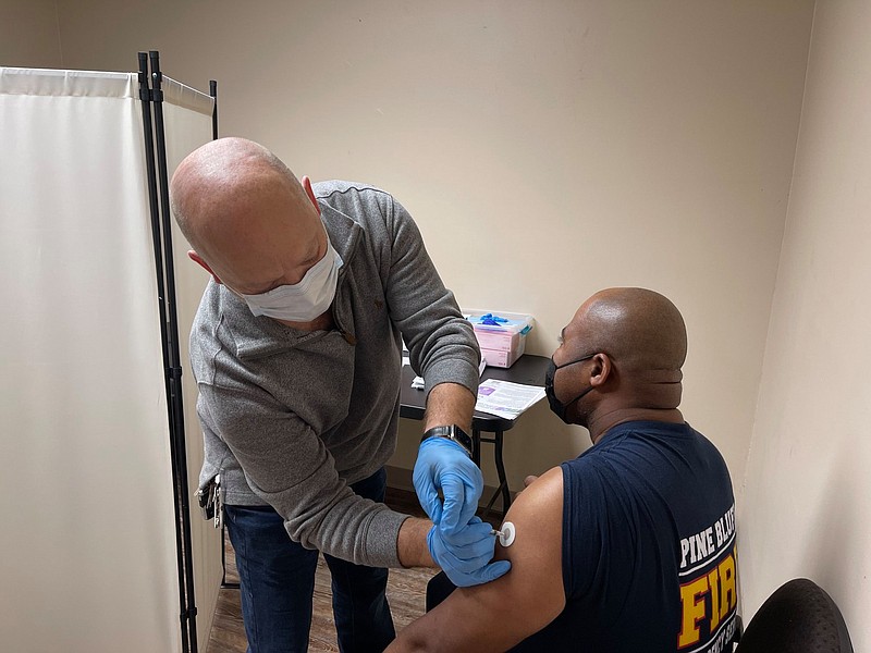 On Jan. 7, Lt. Fred Batemon was one of the first Pine Bluff firefighters to receive the first of two doses of the covid-19 vaccination at Doctor's Orders Pharmacy. Administering the shot is Pine Bluff Pharmacist Lelan Stice. (Special to the Commercial)