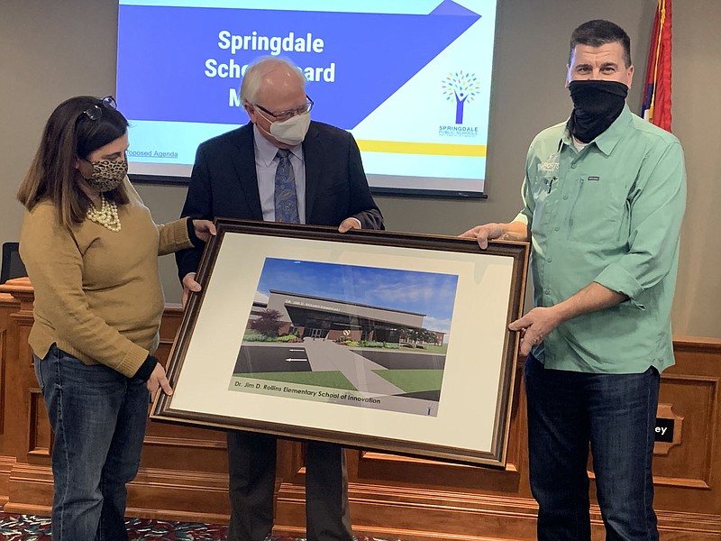 Springdale School Board members Michelle Cook (left) and Randy Hutchinson (right) present former district superintendent of 38 years Jim Rollins (center) with a rendering of Dr. Jim D. Rollins Elementary School Tuesday at a School Board meeting. The 90,000-square-foot school will cost about $21.5 million to complete and will serve some 820 students from kindergarten through fifth grade in Tontitown.