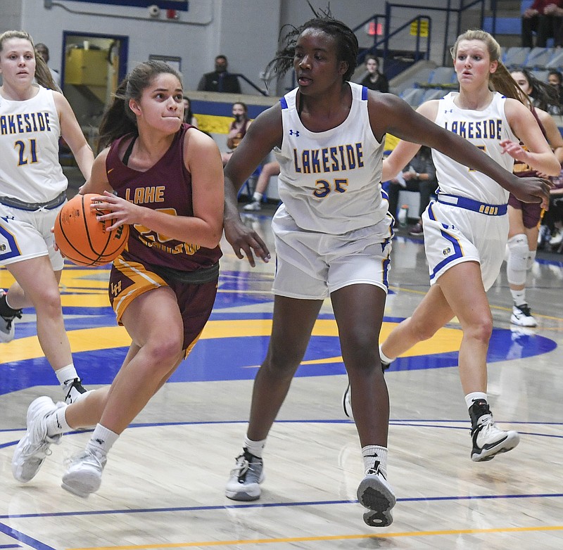 Lake Hamilton's Hayleigh Wyrick (23) goes for a basket as Lakeside's Adachi Igbokidi (35) defends during Tuesday's game at Lakeside Athletic Complex. - Photo by Grace Brown of The Sentinel-Record