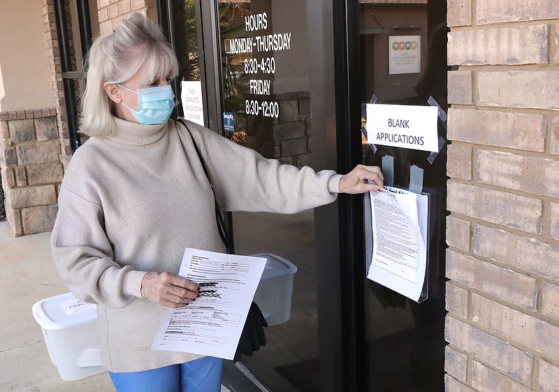 Janice Williams, of Hot Springs, picks up COVID-19 vaccine applications at the Oaklawn Center on Aging offices Wednesday. - Photo by Richard Rasmussen of The Sentinel-Record