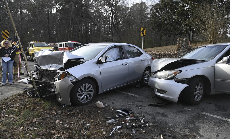 The driver of one of two Toyotas involved in a head-on collision in the 2000 block of Park Avenue on Wednesday looks over the damage to the vehicles. - Photo by Grace Brown of The Sentinel-Record story.lead_photo.caption