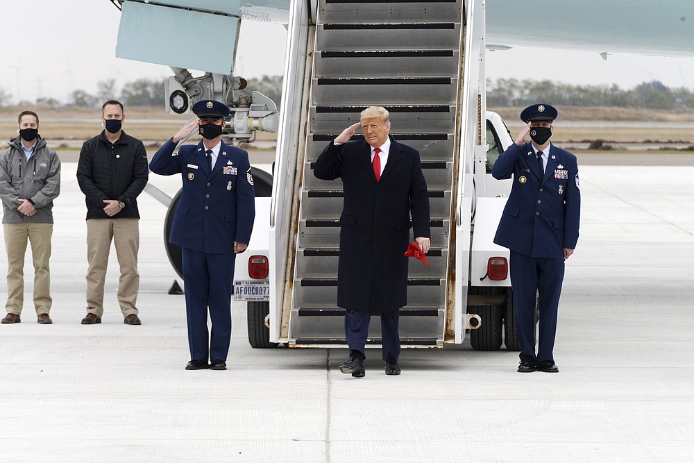 President Donald Trump salutes as he steps off Air Force One upon arrival at Valley International Airport, Tuesday, Jan. 12, 2021, in Harlingen, Texas. (Miguel Roberts/The Brownsville Herald via AP)