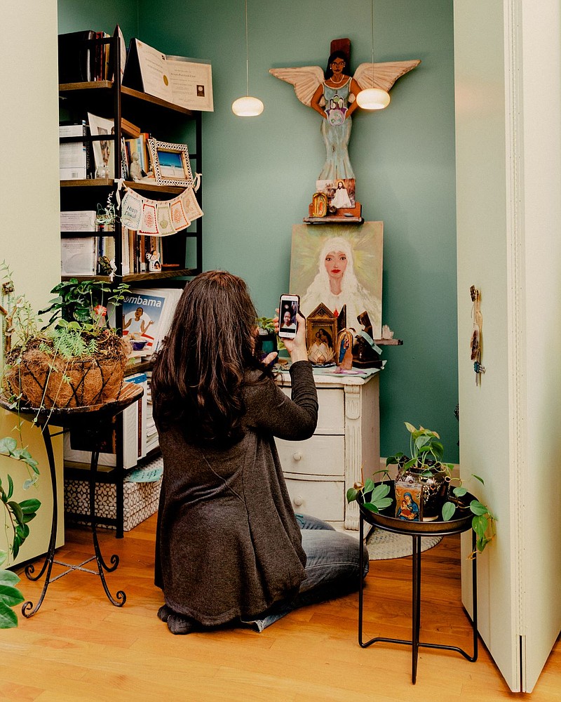 Susan Pannier-Cass, a spiritual director and ordained minister, kneels at an altar in her home in Chicago, Dec. 11, 2020. (Evan Jenkins/The New York Times)