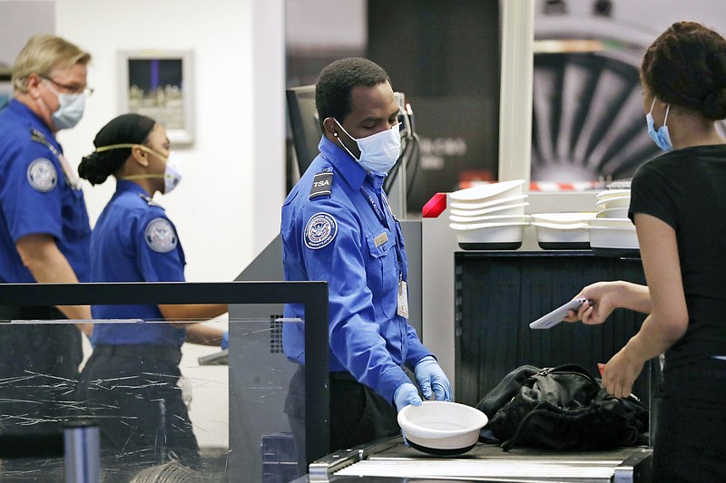 TSA officers wear protective masks at a security screening area at Seattle-Tacoma International Airport on May 18, 2020, in SeaTac, Wash. Airlines say they are stepping up security on flights to Washington before next week’s inauguration of President-elect Joe Biden. Delta, United and Alaska airlines said Thursday they will bar passengers flying to Washington from putting guns in checked bags. - AP Photo/Elaine Thompson