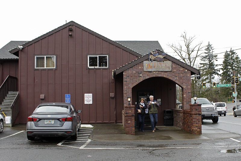 Customers remove their masks as they emerge after dining at the Carver Hangar in Boring, Ore., on Jan. 6, 2021. As coronavirus deaths soar, a growing number of restaurants like Carver Hangar in states across the country are reopening in defiance of strict COVID-19 rules that have shut them down for indoor dining for weeks, or even months. (AP Photo/Gillian Flaccus)