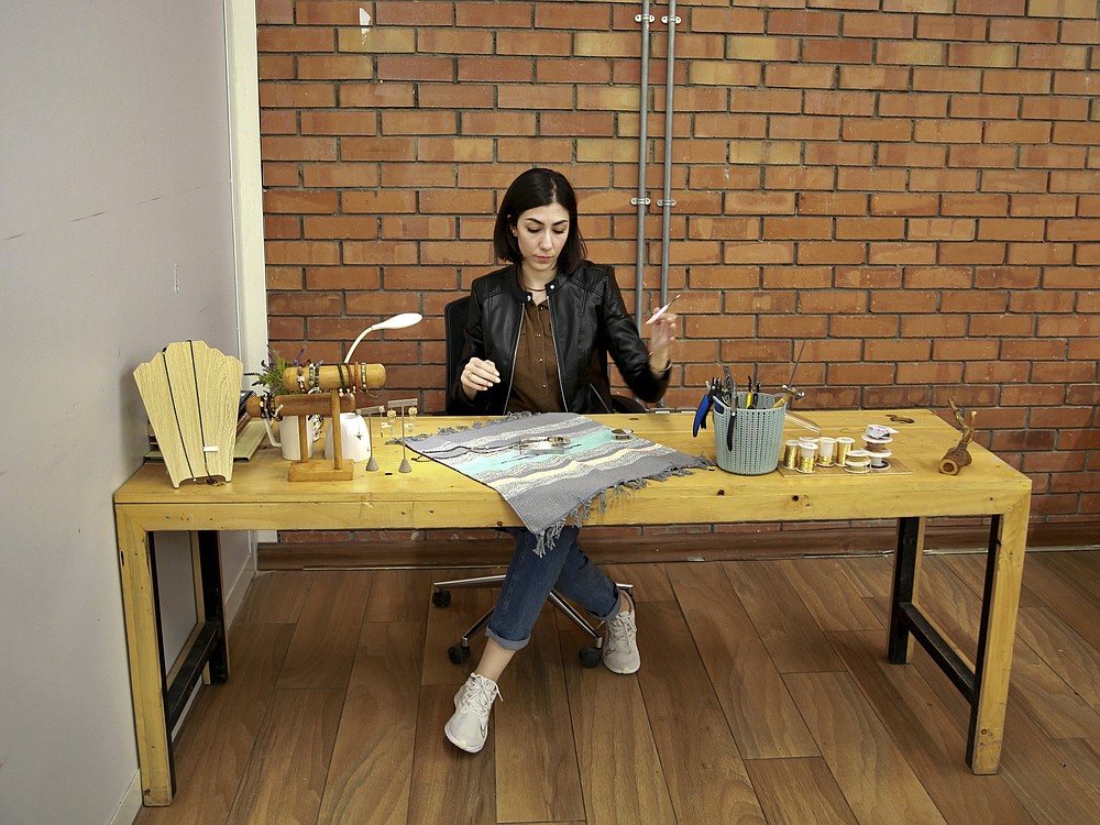 Mariam Khzarjian works on her jewelry in Baghdad, Iraq, Saturday, Dec. 5, 2020. In late 2018 Khzarjian decided to start her own home-based business consisting of handmade jewelry inspired by Armenian traditions. The pandemic forced her to focus, working on new designs and techniques during curfews. The move toward online shopping helped her business take off in a way she could not have imagined. (AP Photo/Khalid Mohammed)