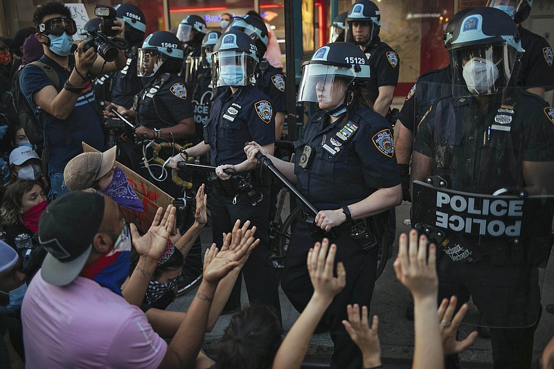 FILE - This May 31, 2020 file photo shows New York City Police facing off with activists during a protest march in the Bedford-Stuyvesant section of the Brooklyn borough of New York.  New York’s attorney general sued the New York Police Department on Thursday, Jan. 14, 2021 alleging the rough treatment of protesters last spring in the wake of George Floyd’s killing was part of a longstanding pattern of abuse that stemmed from inadequate training, supervision and discipline.  (AP Photo/Kevin Hagen, FIle)