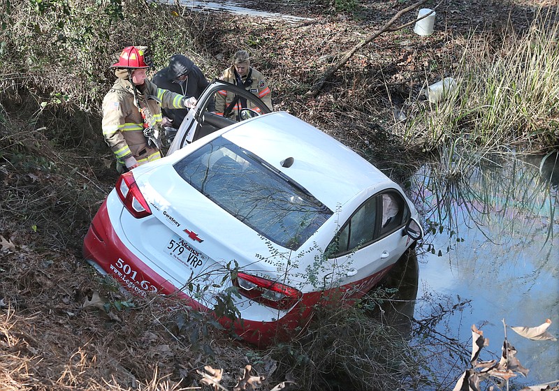 Members of the 70 West Fire Department work the scene of a single-vehicle wreck in the 400 block of Majestic Lodge Road Friday. - Photo by Richard Rasmussen of The Sentinel-Record