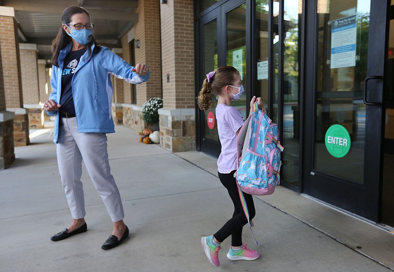 Nancy Lang, head of school at The New School, greets Harlow Hayes, a kindergarten student, Thursday, October 1, 2020, as she enters the school for a day of classes in Fayetteville. Check out nwadg.com/photos for a photo gallery.(NWA Democrat-Gazette/David Gottschalk)