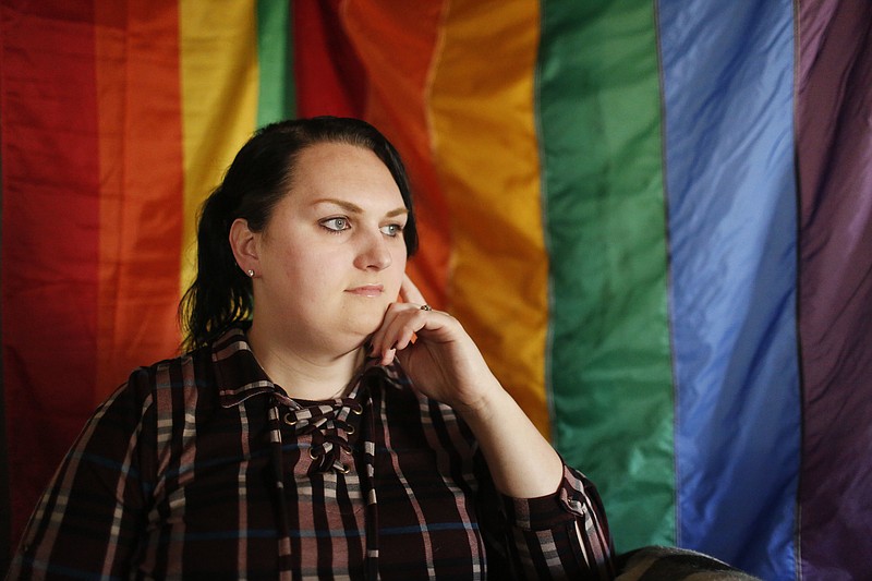 FILE - In this Feb. 6, 2018, file photo, Destiny Clark, 33, of Odenville, Ala., sits in front of a pride flag for a portrait in Odenville, Ala. Alabama’s policy requiring a transgender person to undergo full gender reassignment surgery before they can change the sex on their driver’s license is unconstitutional, a federal judge ruled Friday, Jan. 15, 2021. (AP Photo/Brynn Anderson, File)