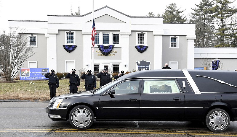 FILE - In this Thursday, Jan. 14, 2021. file photo, Norton, Mass. police salute as a hearse carrying colleague Det. Sgt. Stephen Desfosses briefly stops in front of the police station. Desfosses, 52, a local police officer for 32 years, died of the coronavirus Wednesday in Boston with members of his family by his side, Police Chief Brian Clark said in a statement. Coronavirus deaths are rising in nearly two-thirds of American states as a winter surge pushes the overall toll toward 400,000 amid warnings that a new, highly contagious variant is taking hold. (Mark Stockwell/The Sun Chronicle via AP)