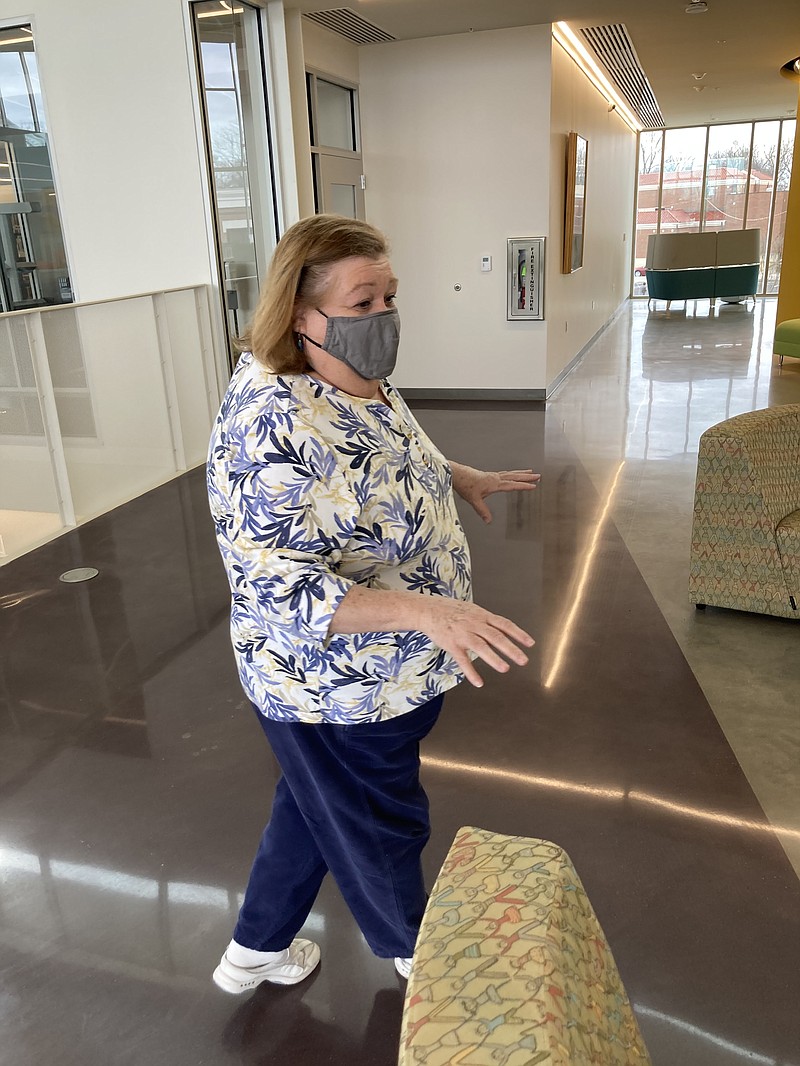 Librarian Bobbie Morgan, who was back on the job on Tuesday, discusses a sitting area where people will be able to congregate and visit. (Pine Bluff Commercial/Byron Tate)
