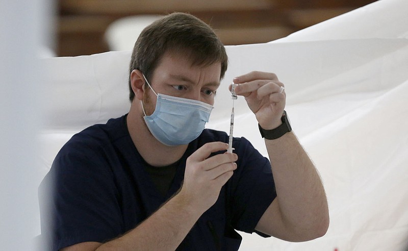 Khristan Yran, with the University of Arkansas for Medical Sciences Northwest College of Pharmacy, draws doses inside the gym.
(NWA Democrat-Gazette/David Gottschalk)