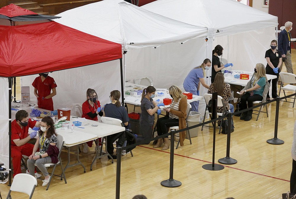 Teachers and staff with the Springdale school district receive a Pfizer covid-19 vaccine shot Wednesday, January 20, 2021, inside the auxiliary gym at Springdale High School. Seven hundred and thirty four Springdale district teachers and staff began receiving their vaccinations Wednesday with the vaccination of 648 continuing today at the Don Tyson School of Innovation. Check out nwaonline.com/210121Daily/ and nwadg.com/photos for a photo gallery.
(NWA Democrat-Gazette/David Gottschalk)
