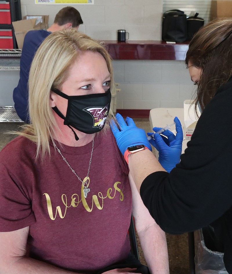 Smith Drug and Compounding employee Courtney Hooker, right, vaccinates Lake Hamilton School District employee Laura Hunt on Friday. - Photo by Richard Rasmussen of The Sentinel-Record