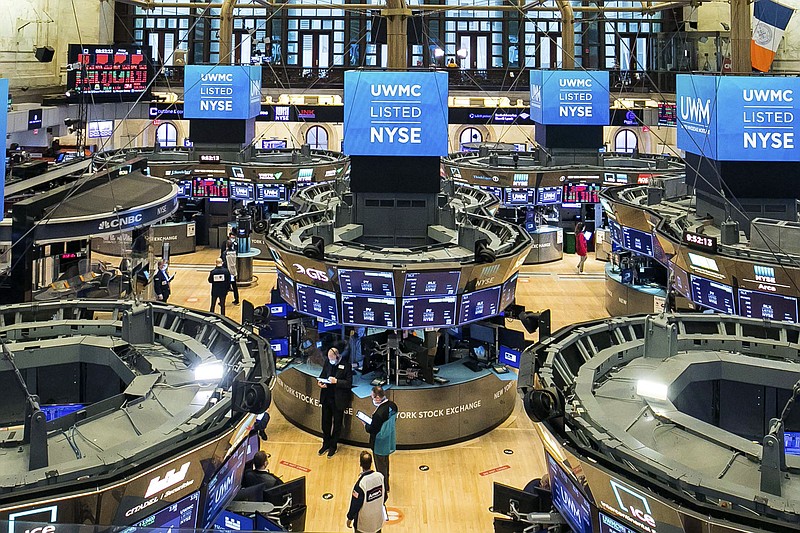 In this photo provided by the New York Stock Exchange, traders work on the floor during the United Wholesale Mortgage IPO, Friday, Jan. 22, 2021. Wall Street is tapping the brakes on its record-setting rally this week, as markets worldwide take a pause on Friday. (Courtney Crow/New York Stock Exchange via AP)