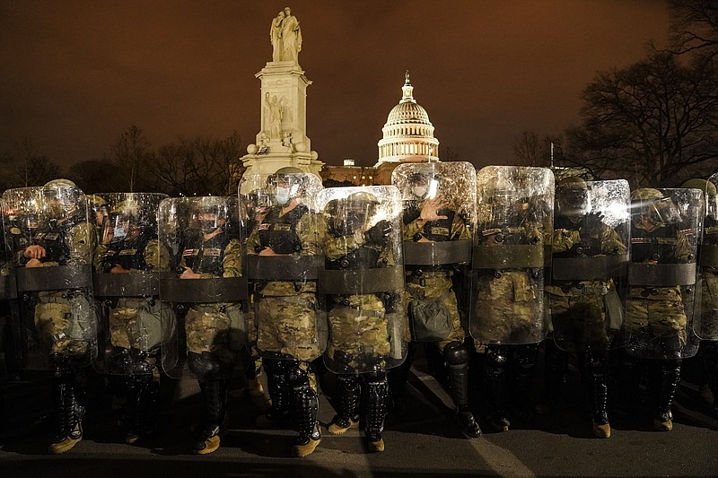District of Columbia National Guard stand outside the Capitol, Wednesday night, Jan. 6, 2021, after a day of rioting protesters. It's been a stunning day as a number of lawmakers and then the mob of protesters tried to overturn America's presidential election, undercut the nation's democracy and keep Democrat Joe Biden from replacing Trump in the White House. (AP Photo/John Minchillo)