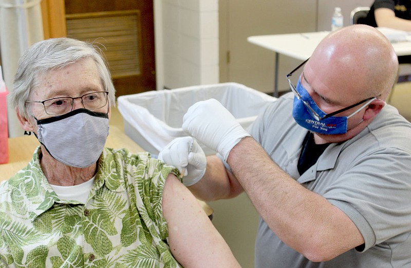 Keith Bryant/The Weekly Vista
Christopher King, left, sits while Central EMS community paramedic Tracy Rieff gives him the first vaccine injection, with a followup injection due three weeks later. King said he heard about the vaccination effort from a POA informational release.