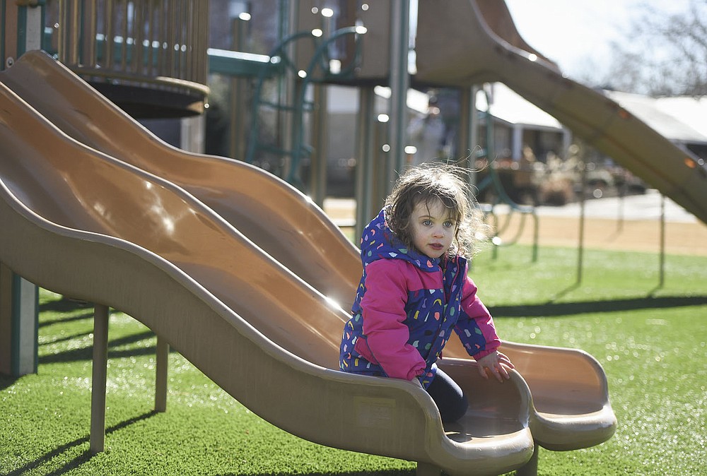 Lynette Henley, 3, of Springdale rides down a slide,¬†Friday, January 23, 2022 at Dave Peel Park in Bentonville. Bentonville residents could be asked to approve $266 million in bonds for street and park improvements as well as other capital projects in the city. The renovations at Dave Peel Park would include the playground, restroom and plaza area. Check out nwaonline.com/210119Daily/ for today's photo gallery. 
(NWA Democrat-Gazette/Charlie Kaijo)