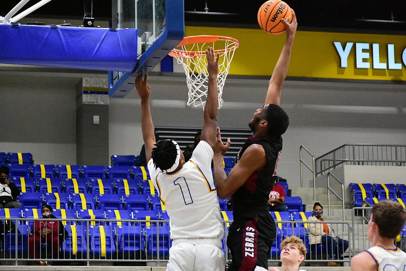 Jordon Harris of Pine Bluff throws down a one-handed dunk against Chris Crew of Sheridan on Saturday in Sheridan. (Pine Bluff Commercial/I.C. Murrell)